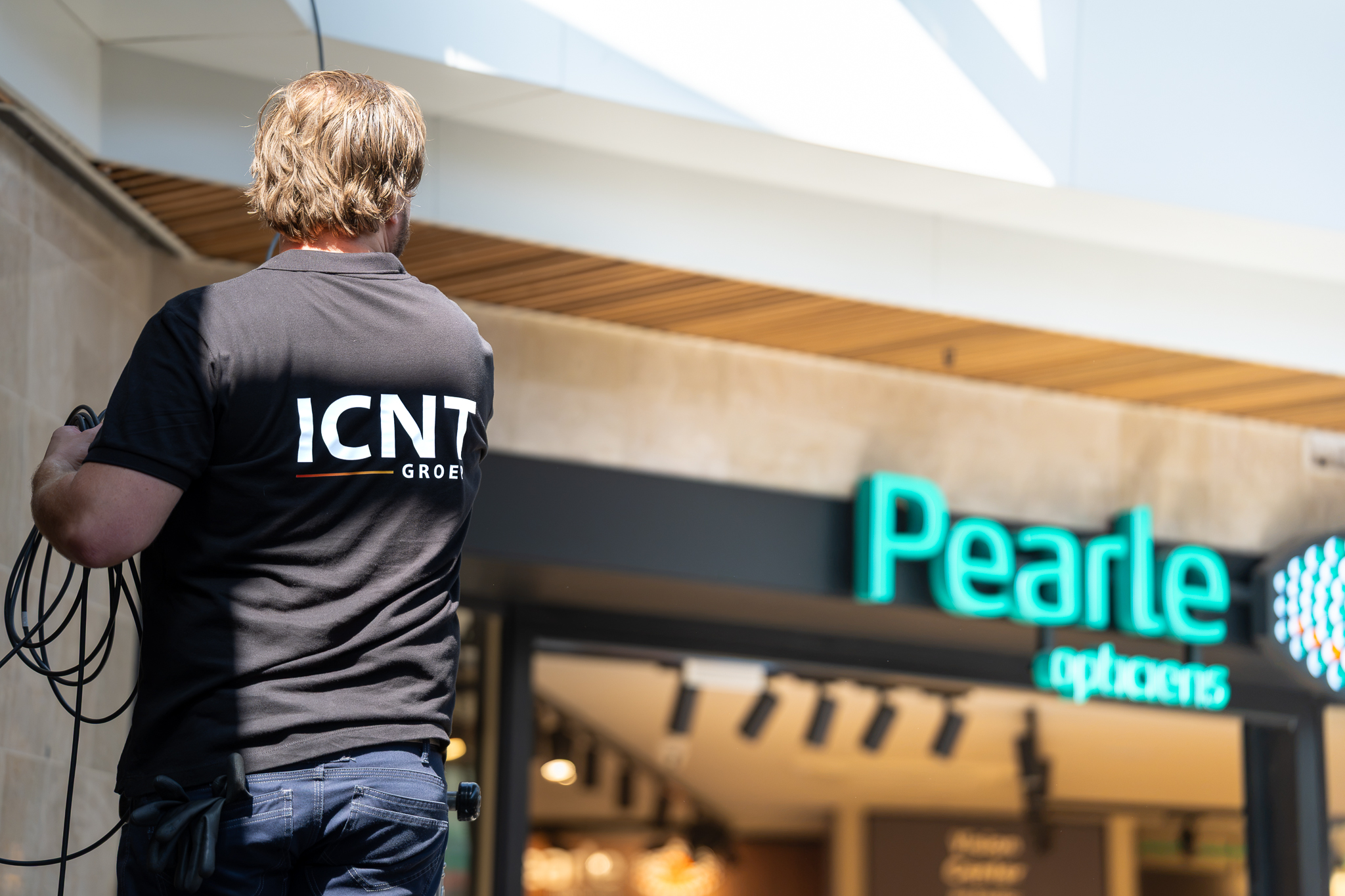 ICNT technician cabling above a Pearle optician storefront
